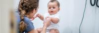 Pediatrician playing with a baby at her office before the examination
